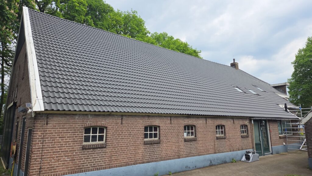 Nieuw antraciet pannendak op een woning met schuur